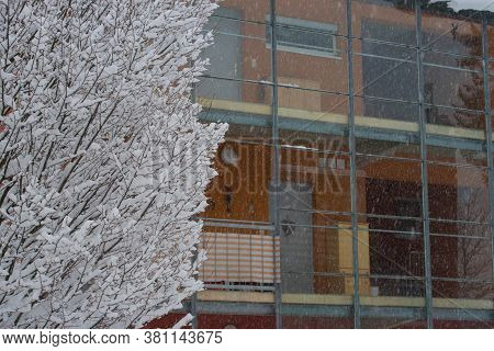 Thermal Insulation In Modern Building In Winter, Snow Fall And Snow Covered Tree