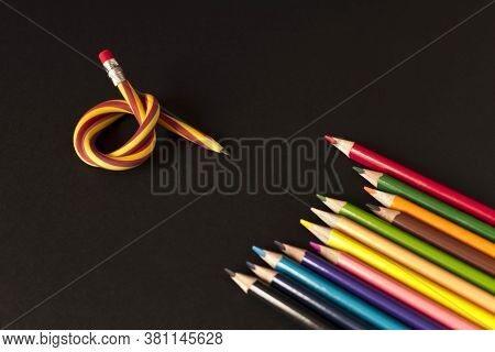 Flexible Pencil And A Set Of Colored Pencils On A Dark Background. Selective Focus
