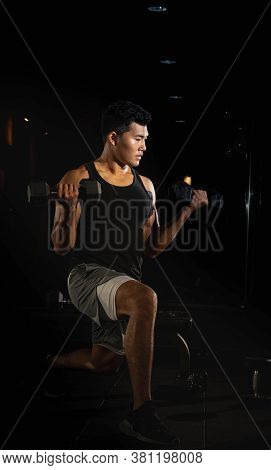 Handsome Man Raising Dumbbell,doing Exercise For Buit Muscle,fit And Firm Body,model Posing,blurry L