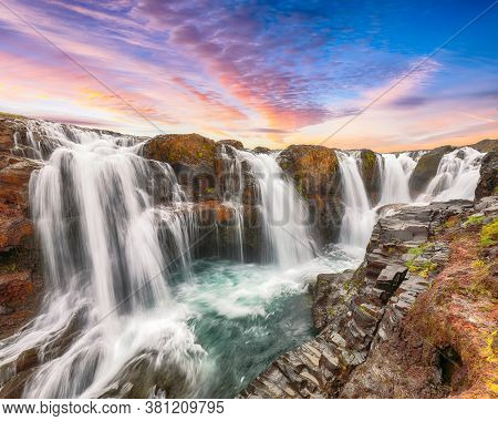 Dramatic View Of  Kolufossar Waterfall At Sunset.  Popular Tourist Travel Destination In Iceland . L