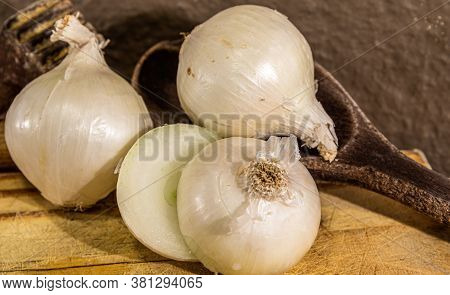 Tubers Of Onions (allium Cepa) Cut In Halves On Wooden Board