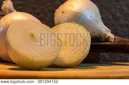 Tubers Of Onions (allium Cepa) Cut In Halves On Wooden Board