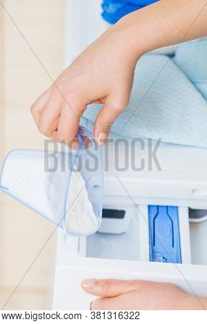 Washing Powder Detergent And Measuring Cup Pouring Into Machine. Household Duties, Clothes Laundry O