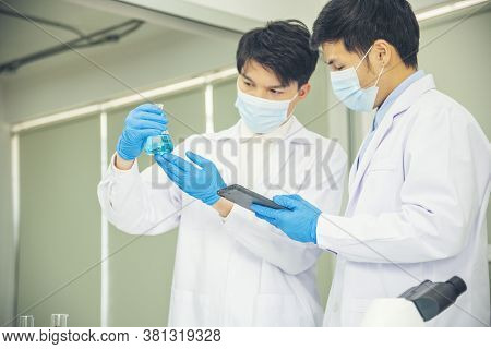 Two Asian Scientist Team Reserch Chemistry Science Tube Experiment Biotech Antibody Sample In Labora