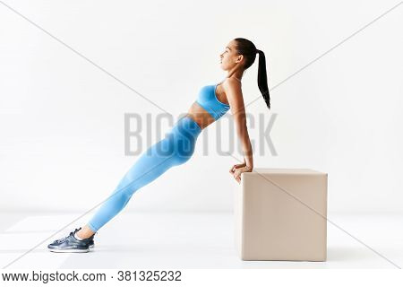 Sporty Woman Making Reverse Plank Exercise On White Background. Sport, Fitness And People Concept