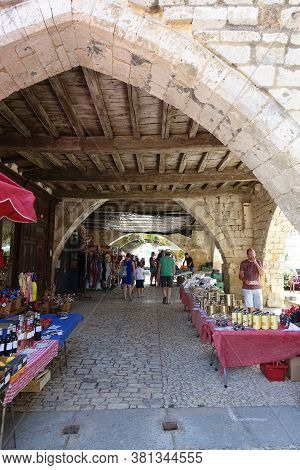 Monpazier, France 09 July 2020: Market Stalls Set Up Under The Medieval Arches In The Town Of Monpaz