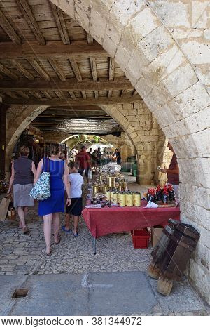 Monpazier, France 09 July 2020: Market Stalls Set Up Under The Medieval Arches In The Town Of Monpaz