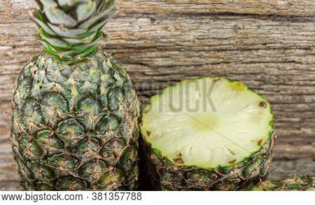 Halved Pineapple Fruit On Woody Background