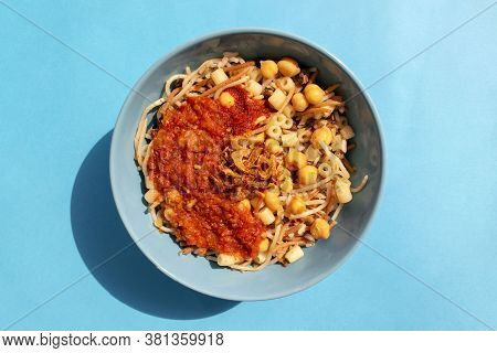 Famous Traditional Arabic, Egyptian Dish - Koshari. National Kushari In A Turquoise Plate On Blue Ba