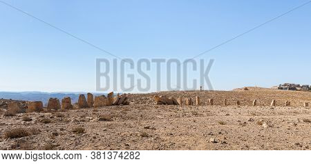 Large Boulders Stand In A Specific Order At Dawn In A Public Sculpture Park In The Desert, On A Clif
