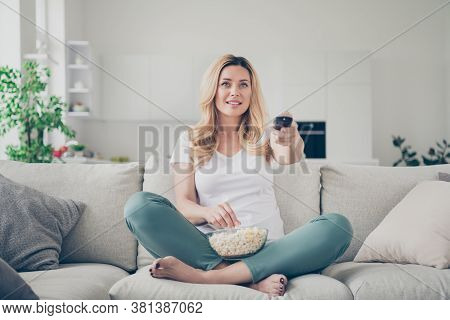 Photo Of Pretty Domestic Beautiful Lady Sit Couch Eat Popcorn Remote Control Change Channel Watch Tv