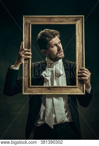 Out Of Time. Young Man In Suit As Dorian Gray Isolated On Dark Green Background. Retro Style, Compar