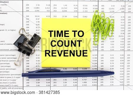 Text Time To Count Revenue On Financial Tables With Pen And Paper Clips