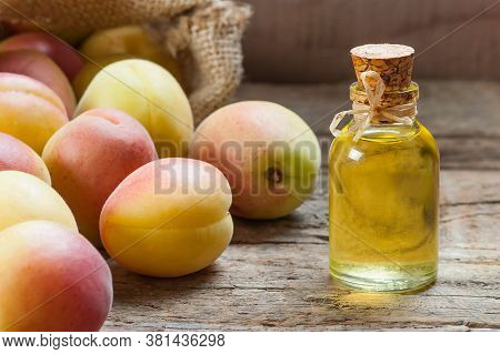 Glass Bottle Of Apricot Seed Kernel Oil ( Prunus Armeniaca Oleum ) With Fresh Ripe Apricot Fruits On