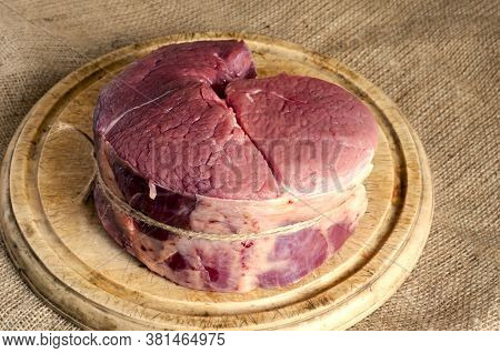 4 Pounds Of Raw Beef On A Wooden Chopping Board. Piece Of Beef Carcass Is Round. Butcher's Shop. Sid