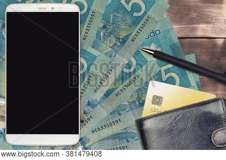 5 Canadian Dollars Bills And Smartphone With Purse And Credit Card. E-payments Or E-commerce Concept