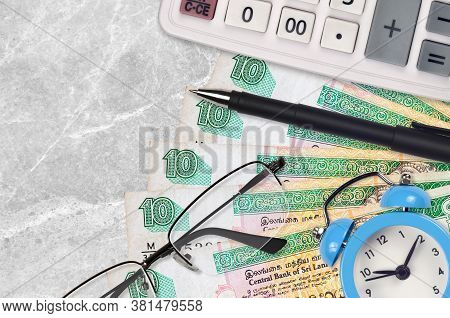 10 Sri Lankan Rupees Bills And Calculator With Glasses And Pen. Business Loan Or Tax Payment Season 