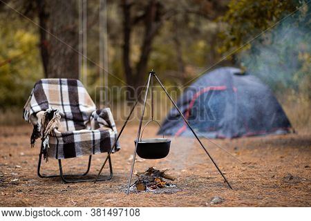 Relaxing And Preparing Food On Campfire In Camping, Autumn Rest In Forest