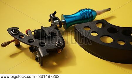 Tattoo Equipment, Tattoo Ink Plastic Stand For Tattoo Ink Caps And Tattoo Machines On Yellow Backgro