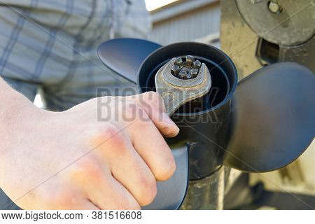 Man Changing Propeller On Outboard Motor. Repairing Outboard Motor For Boat, Replacing Screw.