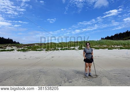 A Female Hiker Exploring The Sandy Beaches Of Nels Bight And Experimental Bight, Surrounded By Fores