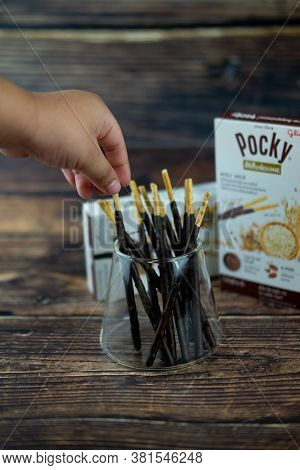 Samut Prakan, Thailand - August 19, 2020 : Hand Little Boy Pick Chocolate Dipped Biscuits Sticks New