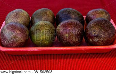Pasiflora Fruits On Plastic Tray On Red Cloth Napkin Background