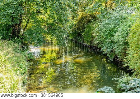 Jeker River Between Maastricht City Park Surrounded By Trees And Abundant Green Vegetation, Sunlight