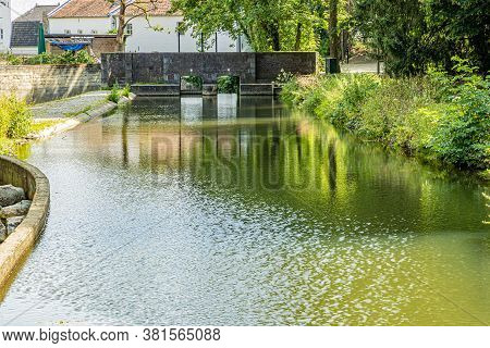 Weir With Its Stone Wall And Two Floodgates On The Jeker River In The City Park Of Maastricht, Sunny