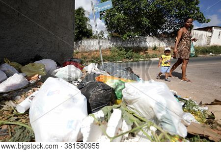 Lauro De Freitas, Bahia / Brazil - March 14, 2019: People Passing By The Garbage Disposal Site In Th