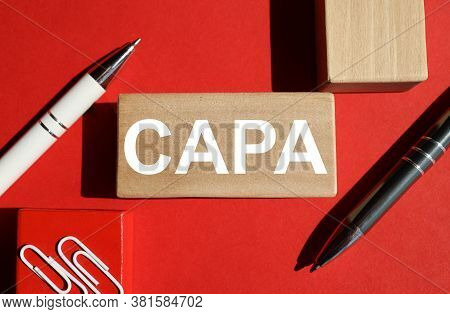 Capa. Corrective And Preventive Action Plans. Word On The Wooden Bar. On A Red Background. Business 