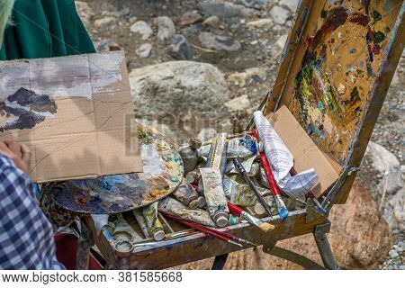 Dombay, Russia 26 July 2020: Close Up Of Young Woman Drawing Picture On Cardboard On Hike. Paintress