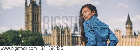 London city Europe travel destination Asian beauty woman at Westminster Houses of Parliament panoramic banner . Autumn holiday lifestyle blue rain coat for fall.