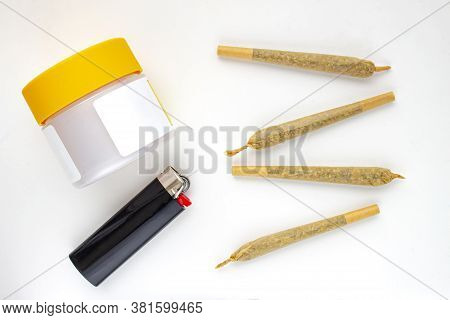 A Cannabis White And Yellow Plastic Packaging Container With Cigarettes, Prerolls Or Joints And A Li