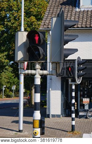 Red Pedestrian Light With A Walking Or Waiting Happy Girl With Ponytail At Crossroads In The Netherl