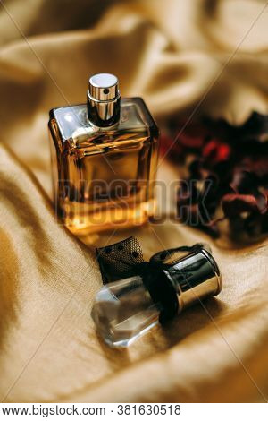 Perfume Bottle On Golden Satin Fabric With Dried Flower Petals, Close-up, Warm Light. . High Quality