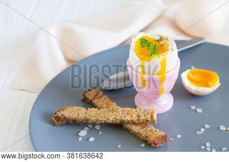 Delicious Breakfast With Hot Soft Boiled Egg In Eggcup, Pink Salt And Toast