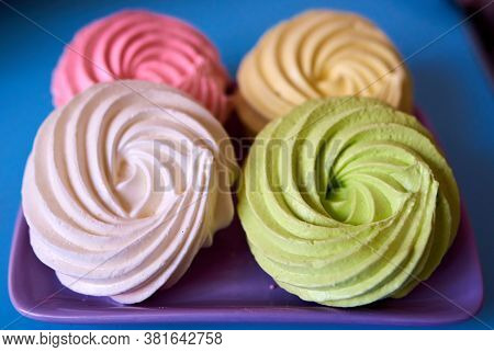 Four Multi-colored Cakes On A Purple Plate