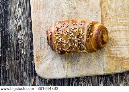 A Wheat Flour Bun Sprinkled With Orange Roasted Peanuts, A Closeup Of A Fresh Soft Bun