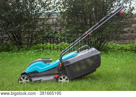 The Lawn Mower Stands On The Grass.