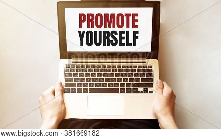 Young Man Checking His Laptop, Top View. Text Promote Yourself