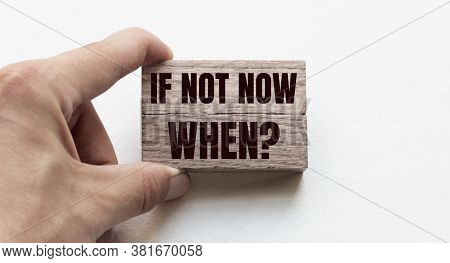 Hand Of A Businessman Holding Wooden Blocks. Conceptual Image. Text If Not Now, When Concept Busines