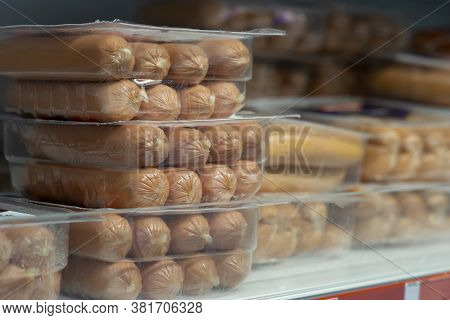 Raw Sausages In Packages On Shelves In A Retail Store. Packets Of Meat At The Supermarket