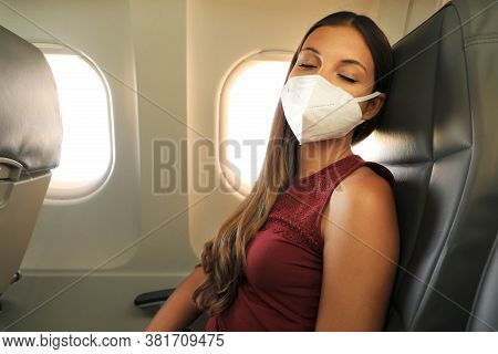 Brazilian Woman With Protective Face Mask Sleeping Relaxed On Airplane Flight During Pandemic Corona