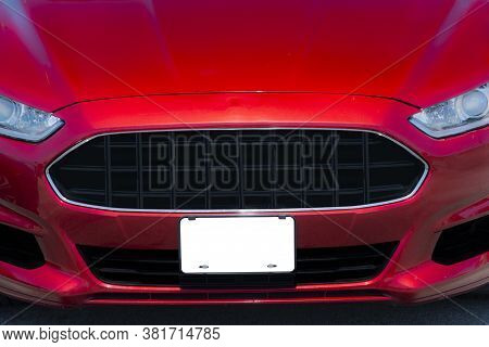 Horizontal Shot Of A Red Automobile With A Blank White Front License Plate With Copy Space.