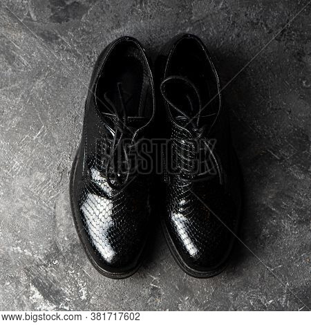 Elegant Unisex Black Shoes Standing On The Concrete Background. Top View.