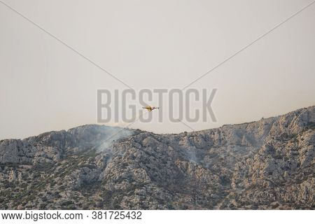 A Fire Fighting Water Bomber Dropping Water On A Forest Fire On Top Of The Kozjak Mountain In Croati