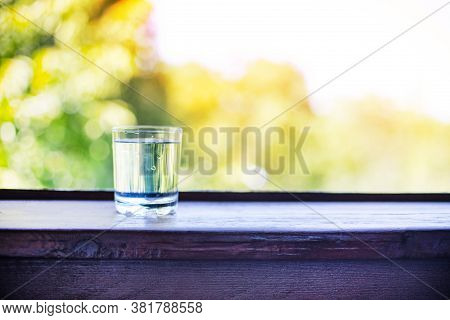 Pure Fresh Water In Glass Glass On A Wooden Table On A Green Natural Background