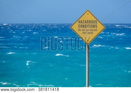 A Sign Beside The Ocean In Hawaii Warning Of Hazardous Conditions