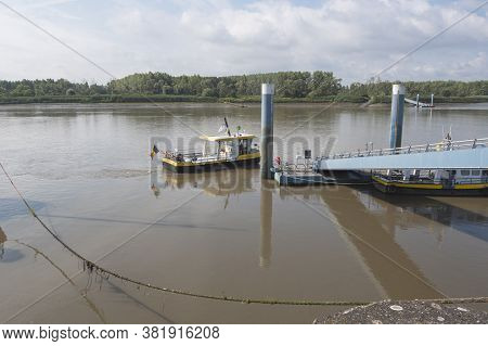 Tielrode, Belgium, 02 August 2020, Yellow Ferry On The Durme River At The Dock